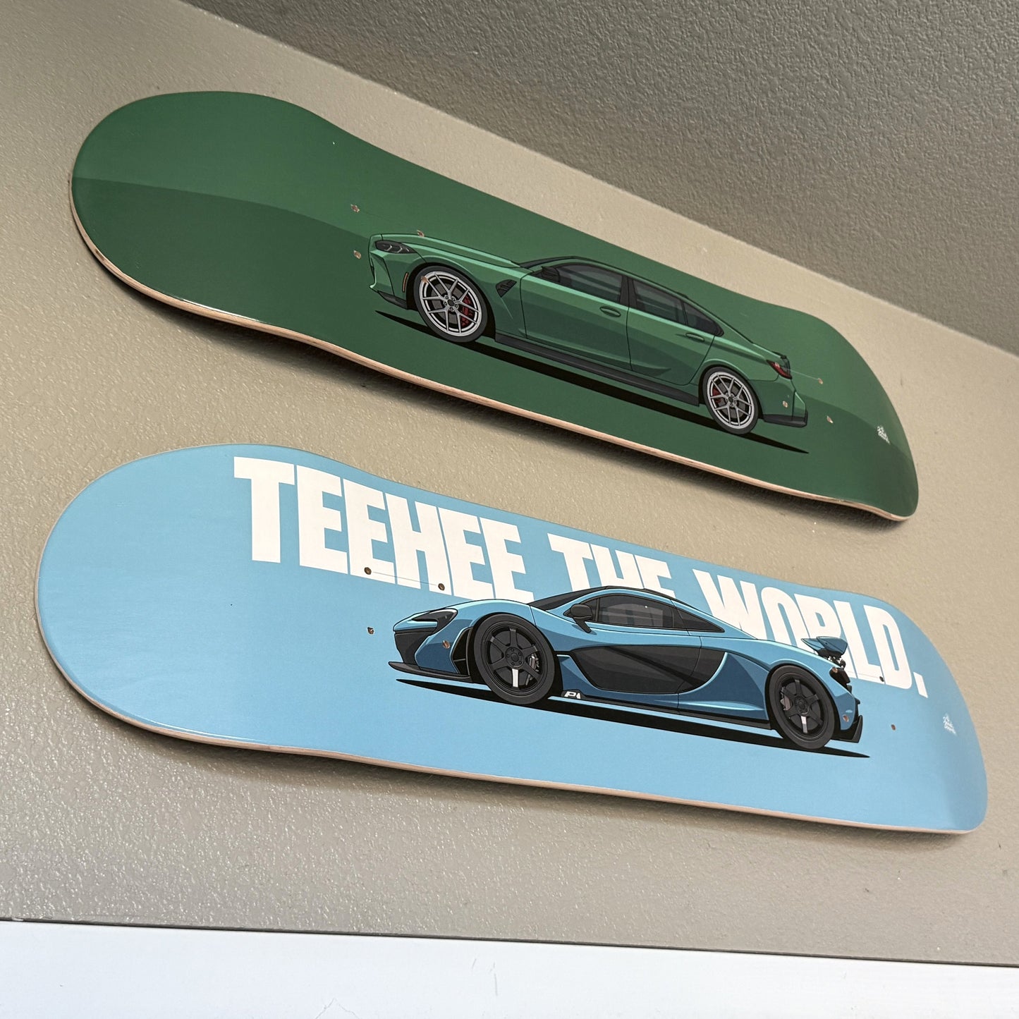 Two skateboard decks with car designs on a neutral background