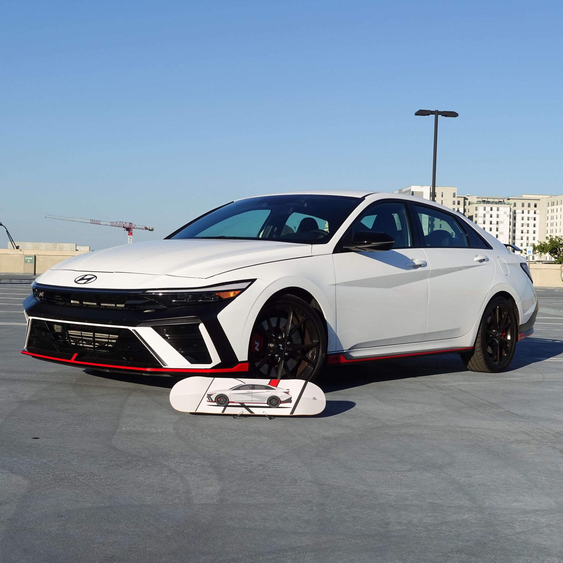White Hyundai car on a concrete surface with a clear blue sky in the background