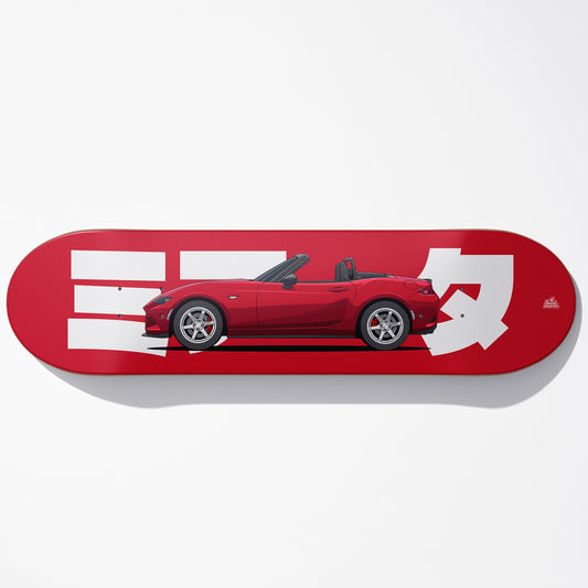 Red skateboard deck with a car illustration and white graphics on a white background